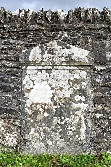 Grave Prints: Old, weathered gravestone on the cemetery wall in Kilmartin