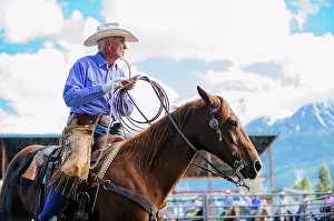 Apparel Prints: Older Caucasian cowboy riding horse at rodeo