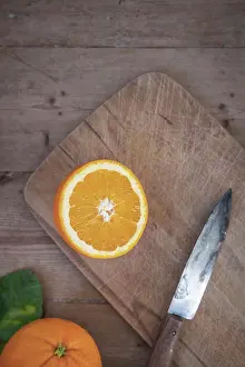 Knife Prints: An orange cut on a cutting board with a knife