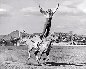 Dangerous Prints: Oregon: c. 1937. A woman stunt rider does a Roman Stand on a fast running palomino quarter horse