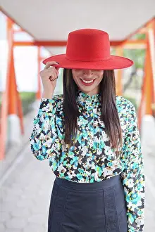 Tartan Prints: outdoor portrait of an attractive young Hispanic woman with red hat