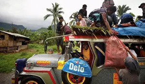Jungle Prints: Overcrowded bus with people sitting on roof passing through rural village outside of Calapan City - Philippines