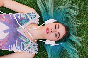 Serene People Prints: Overhead portrait young woman with blue hair listening to music with headphones