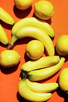 Lemon Prints: Overhead view of bananas and lemons on orange background