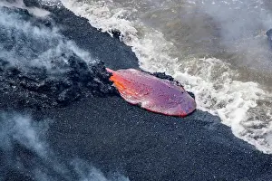 Exterior Space Prints: The Pahoehoe lava flowing from Kilauea has reached a black sand beach and the Pacific ocean near Kalapana