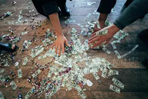 Financial Prints: Several pairs of hands pick up dollar bills from the floor Several pairs of hands pick up dollar bills from the floor