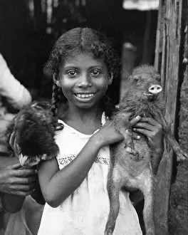 Natives Prints: Panama: c. 1935. A young girl from Panama holding her pet baby peccary