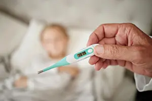 Fever Prints: Parent, hand and reading thermometer for sick child in bed to monitor temperature for fever or covid infection