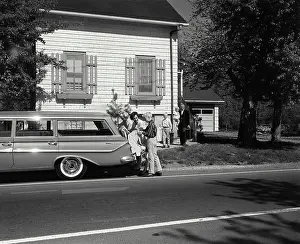 40 45 Prints: Parents and their children loading luggage into a car