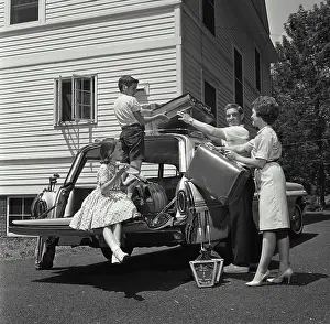 Father Prints: Parents and their children loading luggage into a car