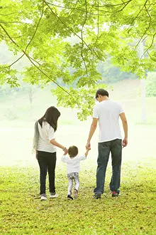 Ausflug Prints: Parents and daughter having fun and walking on green lawn