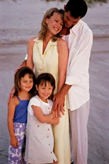 4 5 Years Prints: Parents and their two daughters standing on the beach