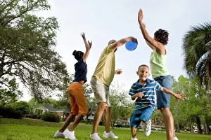 Sports Shoe Prints: Parents playing plastic disk with their children at park