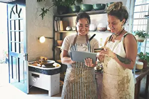 Tablet Prints: Partners, women and smile with tablet at pottery shop on internet for customer reviews