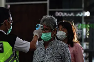 Lockdown Prints: A Passenger wearing a face mask during checked for body temperature when arrival at Yogyakarta Adisutjipto