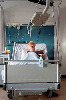 Unwind Prints: Patient in hospital bed reading magazine