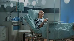 Heavy Prints: Patient in hospital ward talking on videocall with family