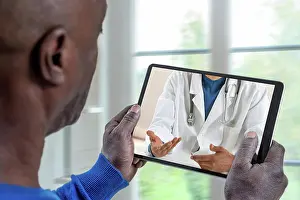 Dialogue Prints: Patient listening to his doctor through the tablet Telemedicine-Patient in front of his doctor 016278_037