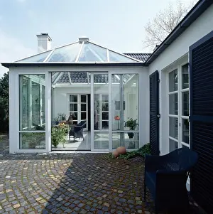 Paving setts in front of conservatory extension on modern white house