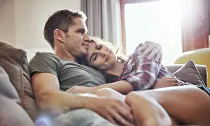 Intimate Prints: Peace, couple and relax on sofa with hug in living room for commitment