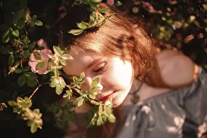 People In Nature Prints: Peaceful young woman sitting amidst flowers in park during summer
