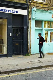Blurred Motion Prints: Pedestrian Walking Along Street Beside Retail Buildings, Brick Lane; London, England