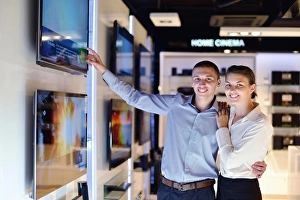 Plasma Prints: people in consumer electronics retail store looking at latest laptop