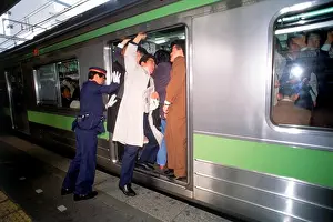 Doors Prints: People getting shoved and pushed into subway train door during Tokyo rush hour