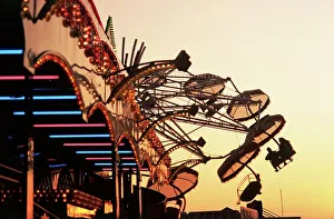 Turning Prints: People riding a carnival way ride at sunset at the the Texas State Fair