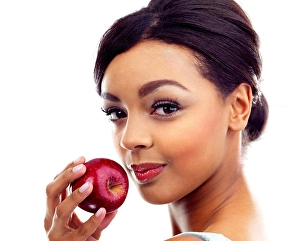 Nutritious Prints: The perfect diet snack. A young woman holding an apple and smiling at the camera
