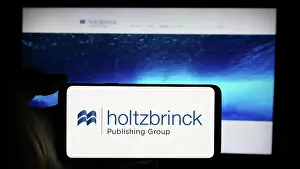 Newspaper Prints: Person holding cellphone with logo of German media company Holtzbrinck Publishing Group
