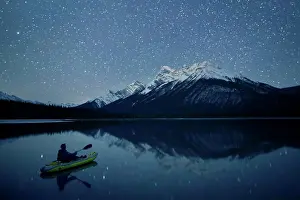 Adventure Prints: Person kayaking on lake at night with view of snowcapped mountain in background
