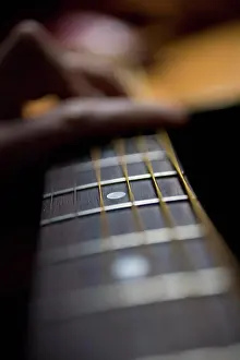 Human Finger Prints: Detail of a person playing an acoustic guitar