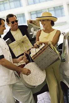 Personal Prints: Personal valet carrying a mid adult woman's shopping bags