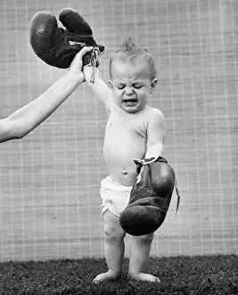 Nappy Prints: Person's hand raising a baby's hand wearing boxing gloves