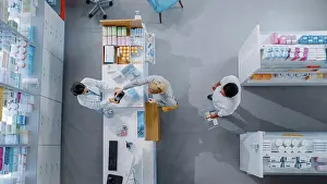 Purchase Prints: Pharmacist and customers at a counter in a pharmacy