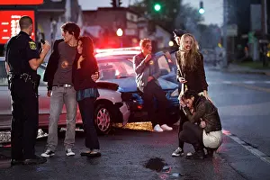 Dangerous Prints: Police officers arriving on scene of automobile accident talking with injured young adults