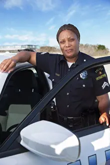 Gleeful Prints: Policewoman standing in door of Police car looking towards camera