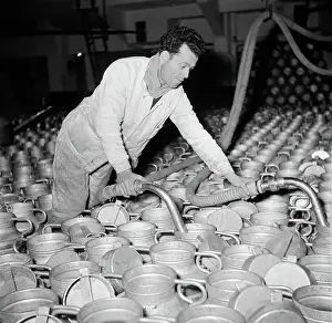 Poll photo collection. Report Paris. Milk factory: Man fills the milk buses. 1950. France, Paris