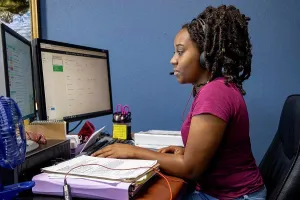 Concentrate Prints: A portrait of an African American woman at her call center desk and her headset