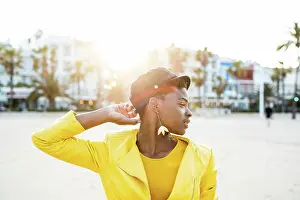 Thoughtful Prints: Portrait of African American woman in stylish bright jacket looking away on sandy beach blurred background
