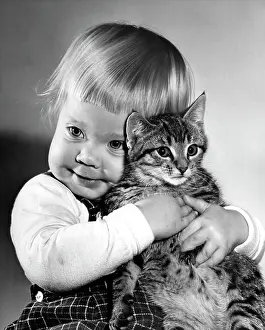 Adolescence Prints: Portrait of baby girl hugging cat