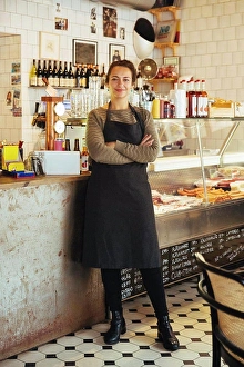 Business And Occupation Prints: Portrait of confident young female owner standing with arms crossed at cafe