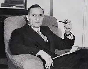 Full Suit Prints: Portrait of Edwin Powell Hubble seated in chair with pipe