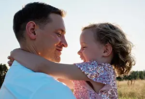 Parenting Prints: portrait of a father holding his daughter laughing at sunset