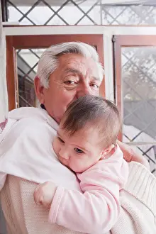 Beginnings Prints: Portrait of a Grandfather Holding New Baby Granddaughter At Home