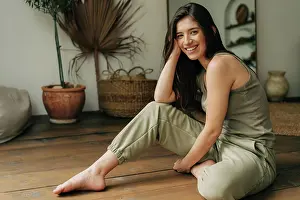 Gelassen Prints: Portrait of a happy cheerful beautiful young brunette woman sitting on the floor
