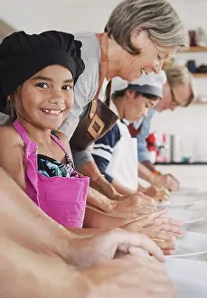 Verticals Prints: Portrait of happy girl preparing food with family in kitchen