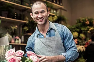 Youngmen Prints: Portrait of happy male florist standing with flowers at shop