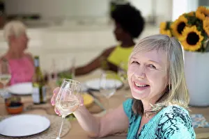 Wineglass Prints: Portrait happy senior woman drinking white wine with friends at table